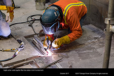 Vogtle worker welds together floor liner plates in Unit 3 containment.