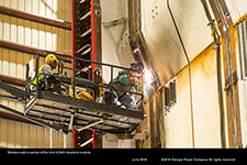 Workers weld a section of the Unit 4 CA01 structural module.