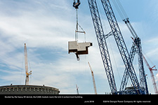 Guided by the heavy lift derrick, the CA05 module nears the Unit 4 containment building.